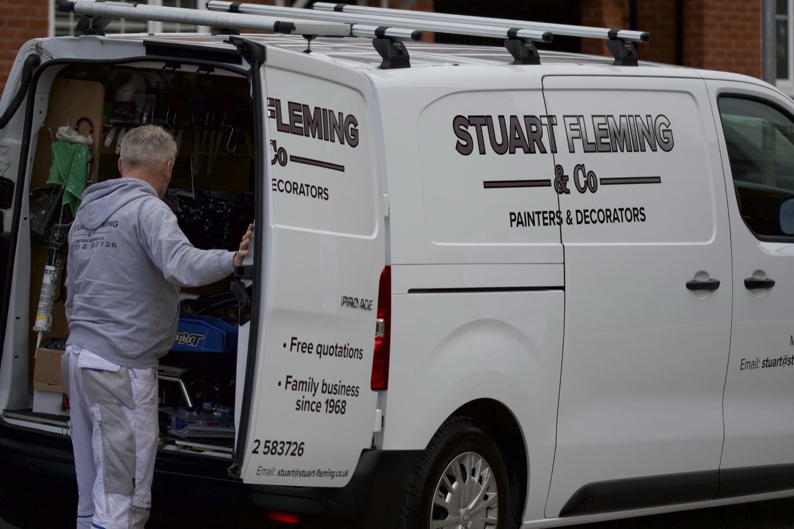 Stuart getting tools from the van, signwriting visible